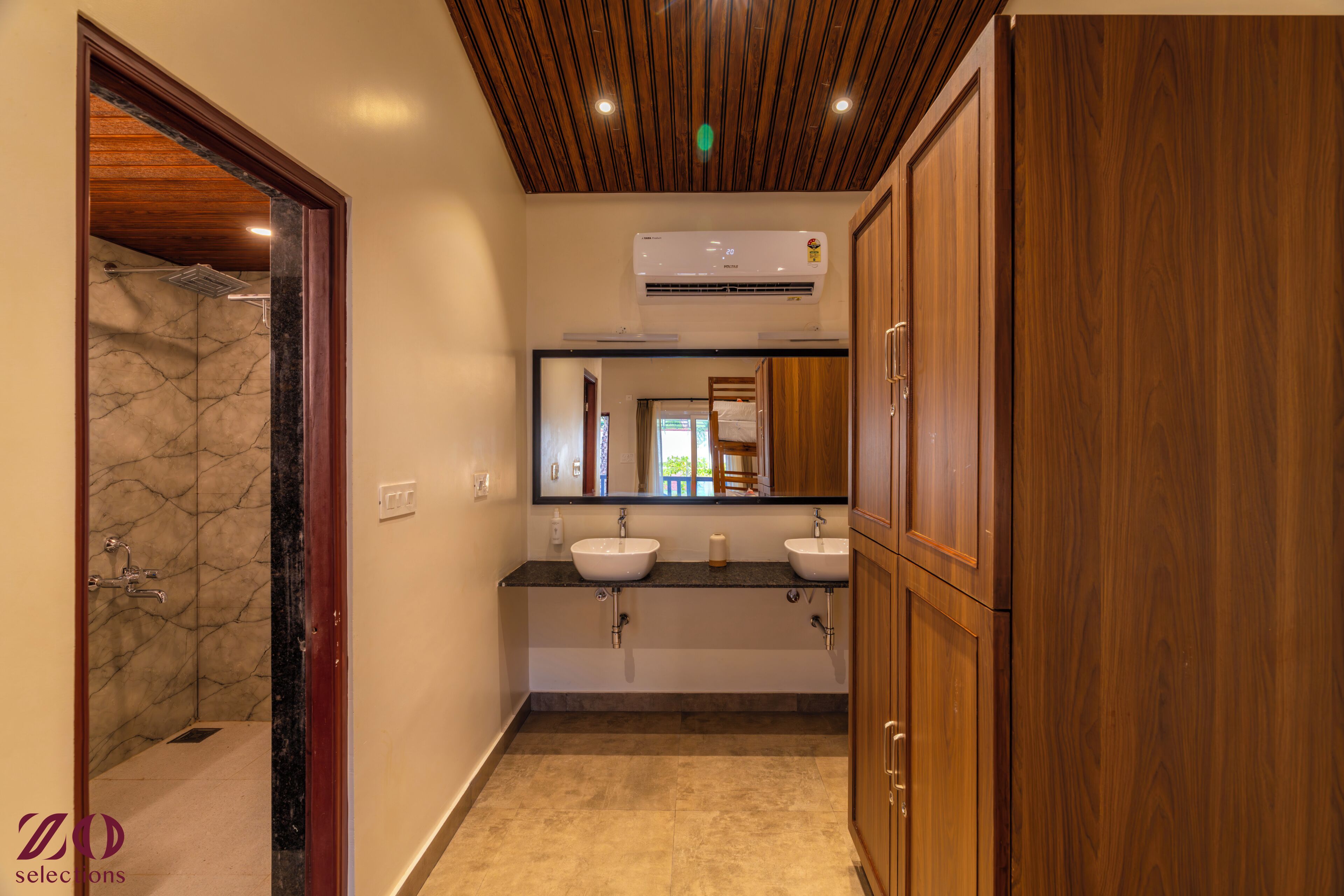 A bathroom with two sinks, a shower, wooden cabinets, and a ceiling with wooden slats.