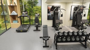 A gym with treadmills, weight machines, a bench, and a rack of dumbbells. - 39 Wireless Hotel (Bangkok)