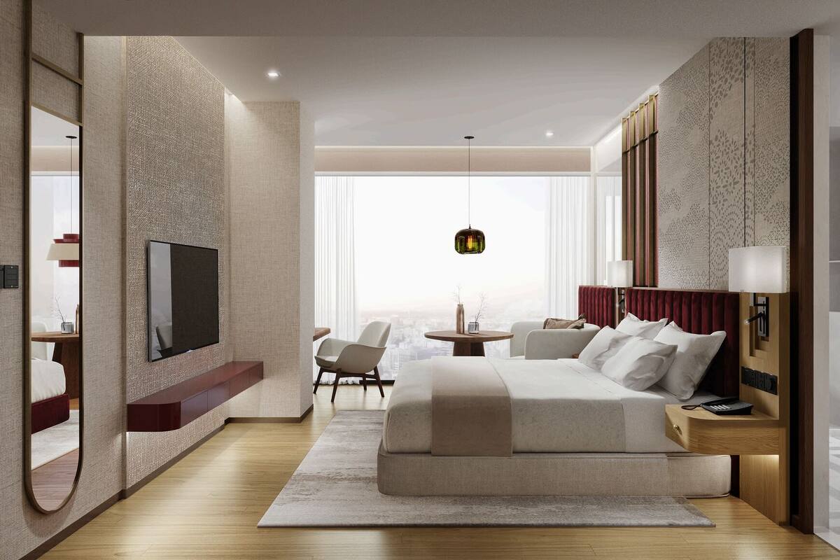 A modern hotel room with a large bed, a TV, a desk, and a view of the city.