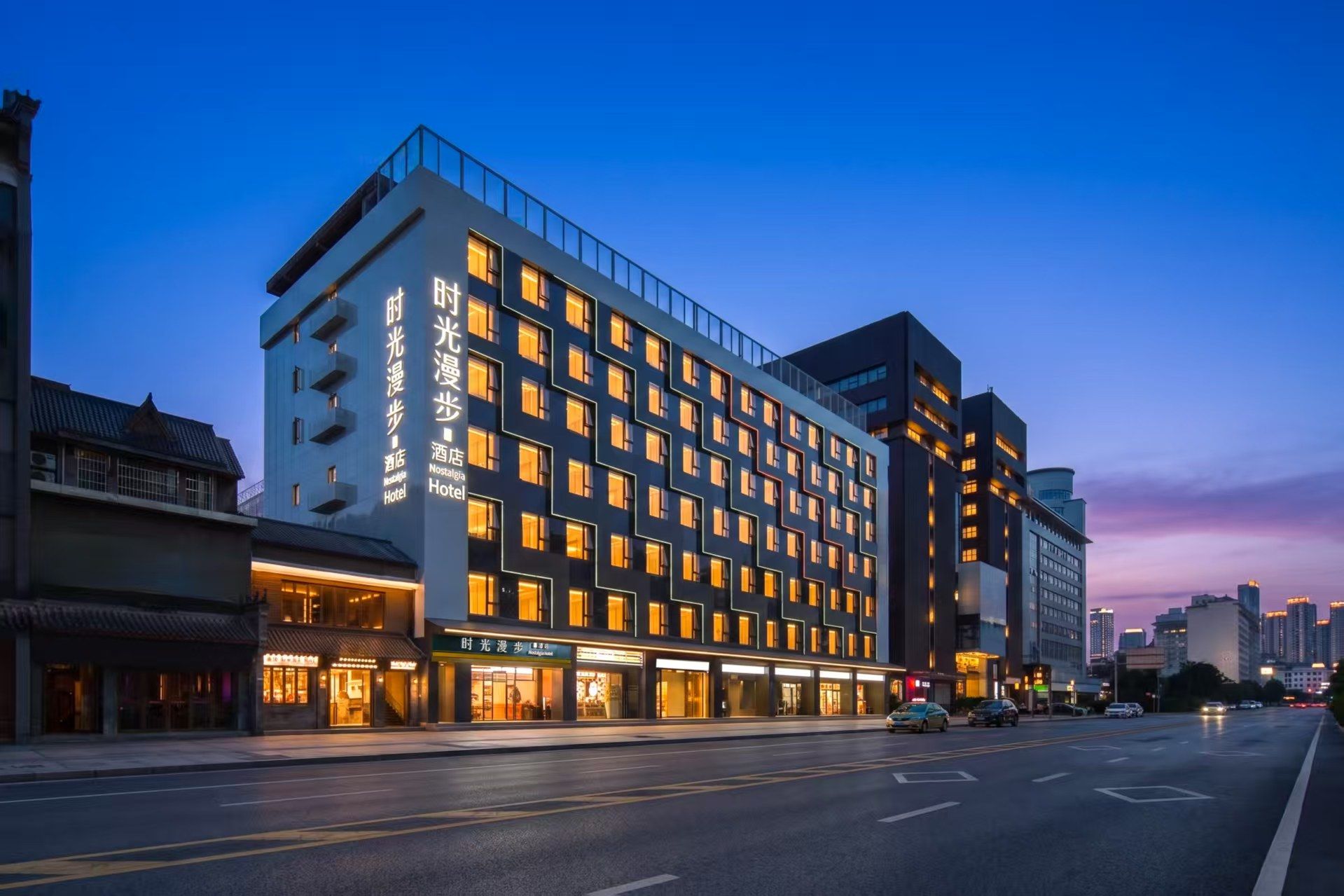 A modern hotel with multiple floors, large windows, and a prominent entrance.
