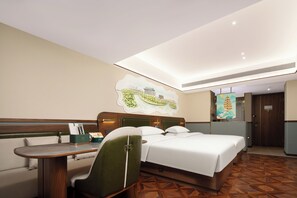 Een hotelkamer met een bed, een bureau, een stoel en een kunstwerk aan de muur.