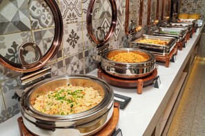 Un buffet proposant divers plats dans des récipients de service en métal.