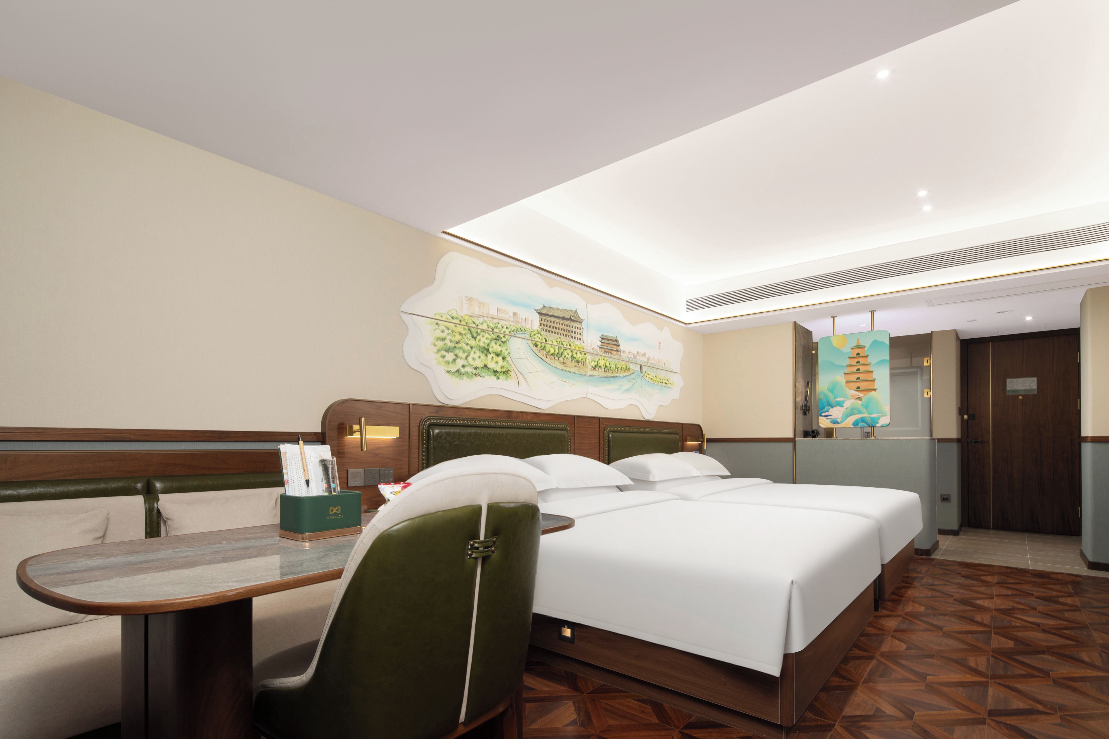 A hotel room with a large bed, a desk, and a chair. There is a painting on the wall and a door with a traditional design.