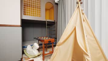 Quarto infantil com beliches, mesa de pebolim e um tipi.