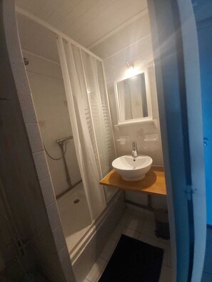 A bathroom with a shower, a sink, and a mirror. - Studio for 4 people, 50 m from the beach, 15 m² terrace + AC + parking (Le Barcarès)
