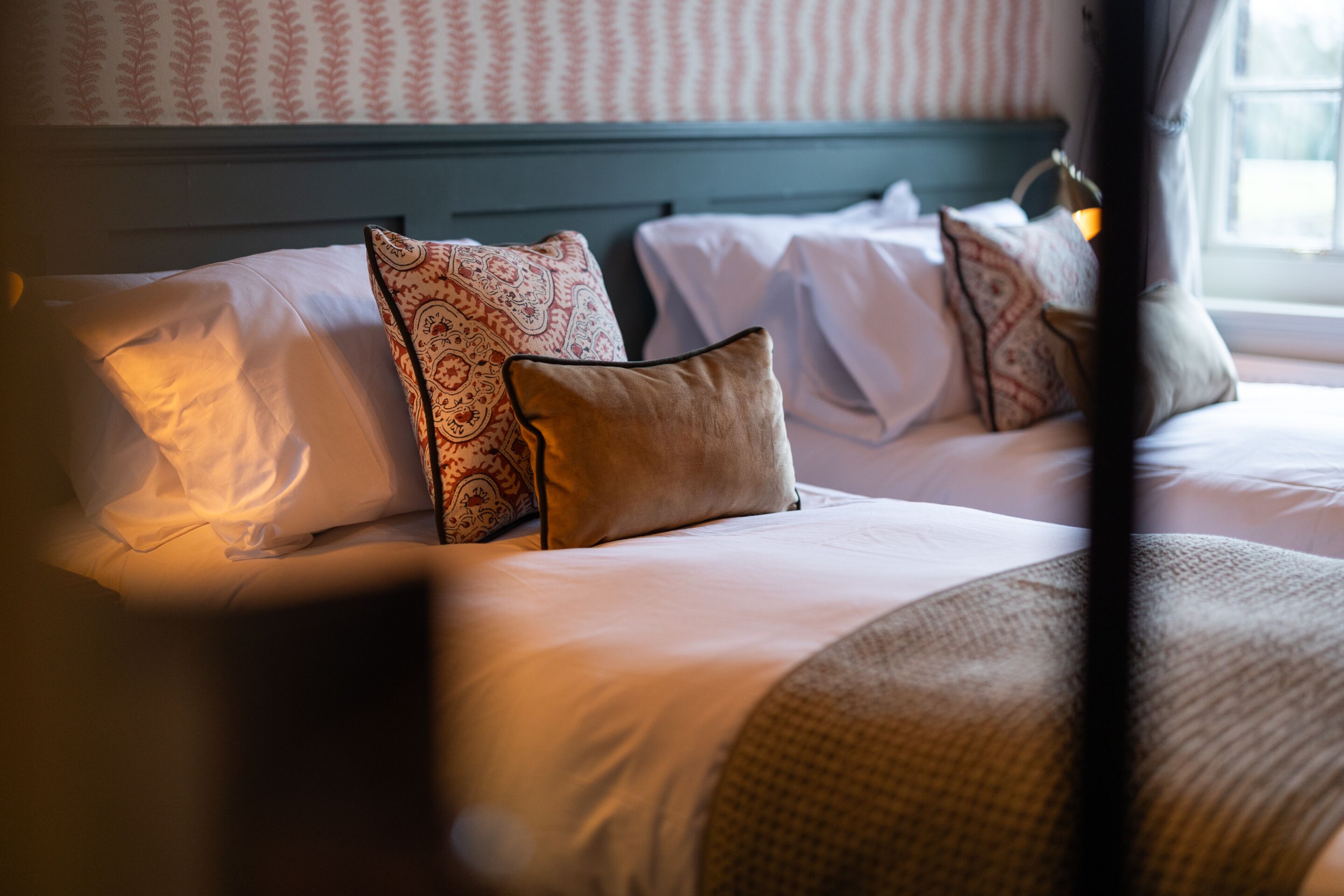 Una habitación de hotel con cama, almohadas y ventana.