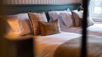 Quarto de hotel com cama, almofadas e janela.