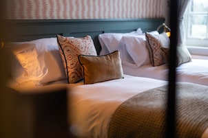Ein Hotelzimmer mit Bett, Kissen und einem Fenster.