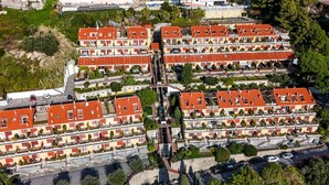 Ein mehrgeschossiges Wohngebäude mit Balkonen, einem Innenhof und einem Parkplatz.