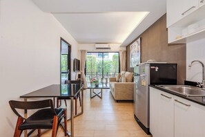 Een moderne keuken met een eetgedeelte, een bank en uitzicht op groen.