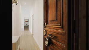 A hallway with a wooden door, a lock, and a keyhole. - Tuscolana Costantino's Apartment by Rentbeat (Roma)