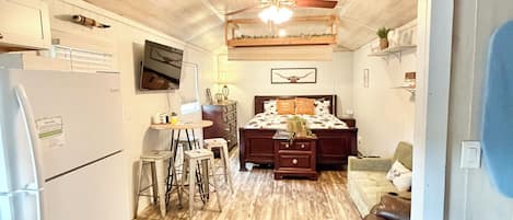 A spacious living area with a wooden ceiling, a dining table, and a sofa.