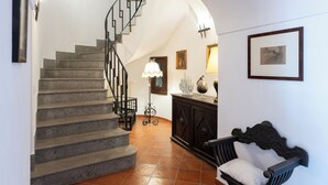 A staircase leading to an upper floor, a bench, and a wall with framed artwork. - Villa Les Paons - Downtown Positano - Terrace (Positano)