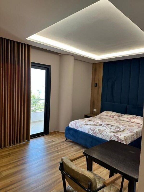 A modern bedroom with a bed, a desk, and a chair. - New Donantelo Hotel (Vlore)