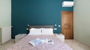 Una camera da letto con un letto, comodini, una porta in legno e un condizionatore d'aria.