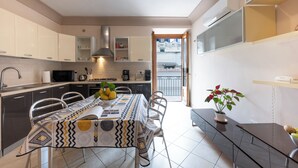 Una cucina moderna con angolo pranzo, elettrodomestici integrati e vista all'esterno.