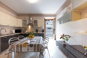 Eine moderne Küche mit Essbereich, integrierten Geräten und Blick ins Freie.