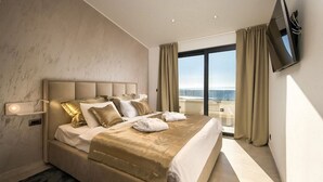 Et hotelværelse med en stor seng, et fjernsyn ophængt på væggen og udsigt over byen fra vinduet.