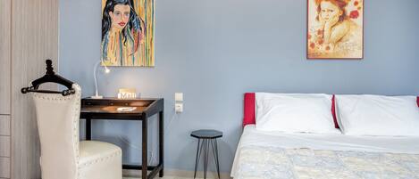 Una camera da letto con un letto, una scrivania, una sedia e due quadri appesi al muro.