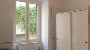 A bedroom with a bed, a window, a radiator, and a wardrobe. - Casa Castaldi - nel Cuore di Trieste (Trieste)