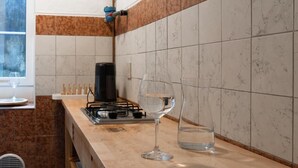 A kitchen with a gas stove, a wine glass, and a water glass on the counter. - Casa Castaldi - nel Cuore di Trieste (Trieste)