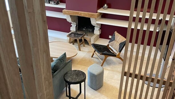 Un salon moderne avec une cheminée, un canapé, une table ronde et un escalier en bois.