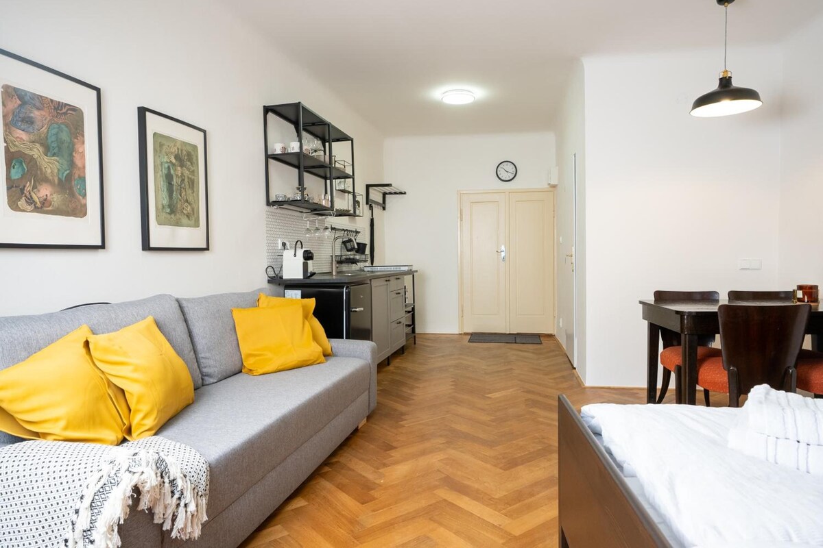 Een knus woongedeelte met een bank, een eettafel en een kitchenette.
