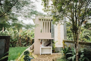 A modern building with a staircase, surrounded by lush greenery and a checkered pathway. - Casa De Arya (Gianyar)