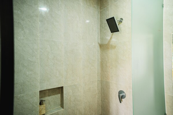 A bathroom with a shower, a sink, and a mirror.