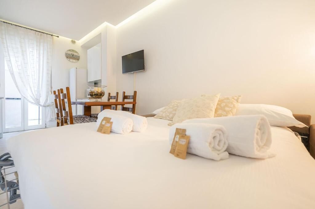 A hotel room with a bed, a desk, and a TV.