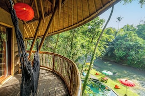 A wooden deck with a curved railing overlooking a river, surrounded by lush greenery. - Bamboo Turtle Ecolodge (Ubud)