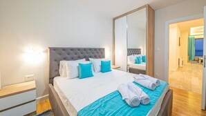 Una camera da letto con un letto grande, uno specchio e vista su un balcone.
