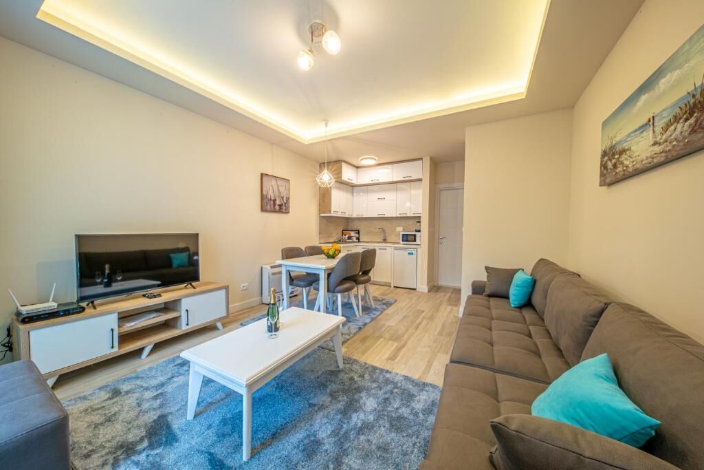A modern living room with a TV, sofa, and dining area.