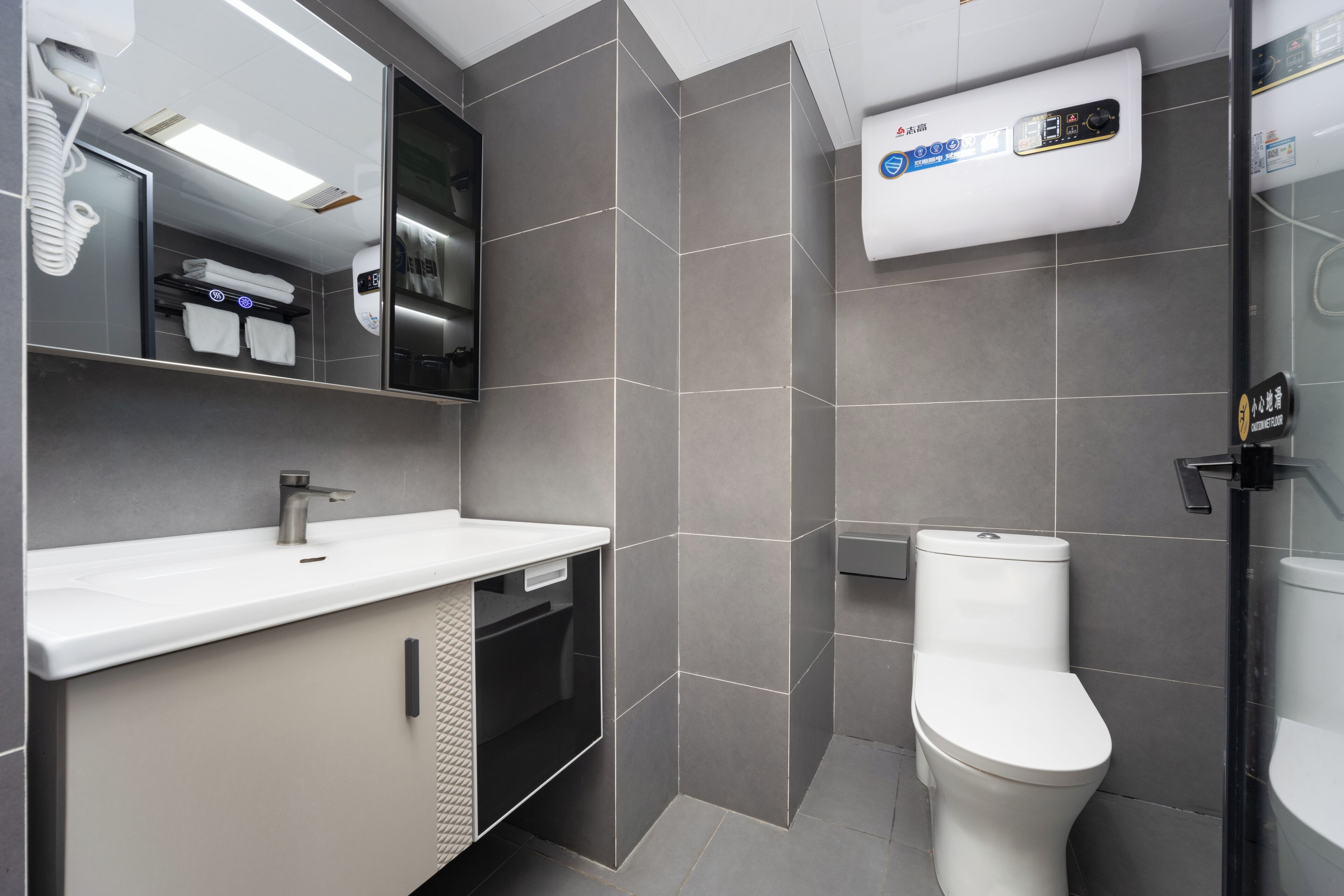 A modern bathroom with a white sink, mirror, and toilet.
