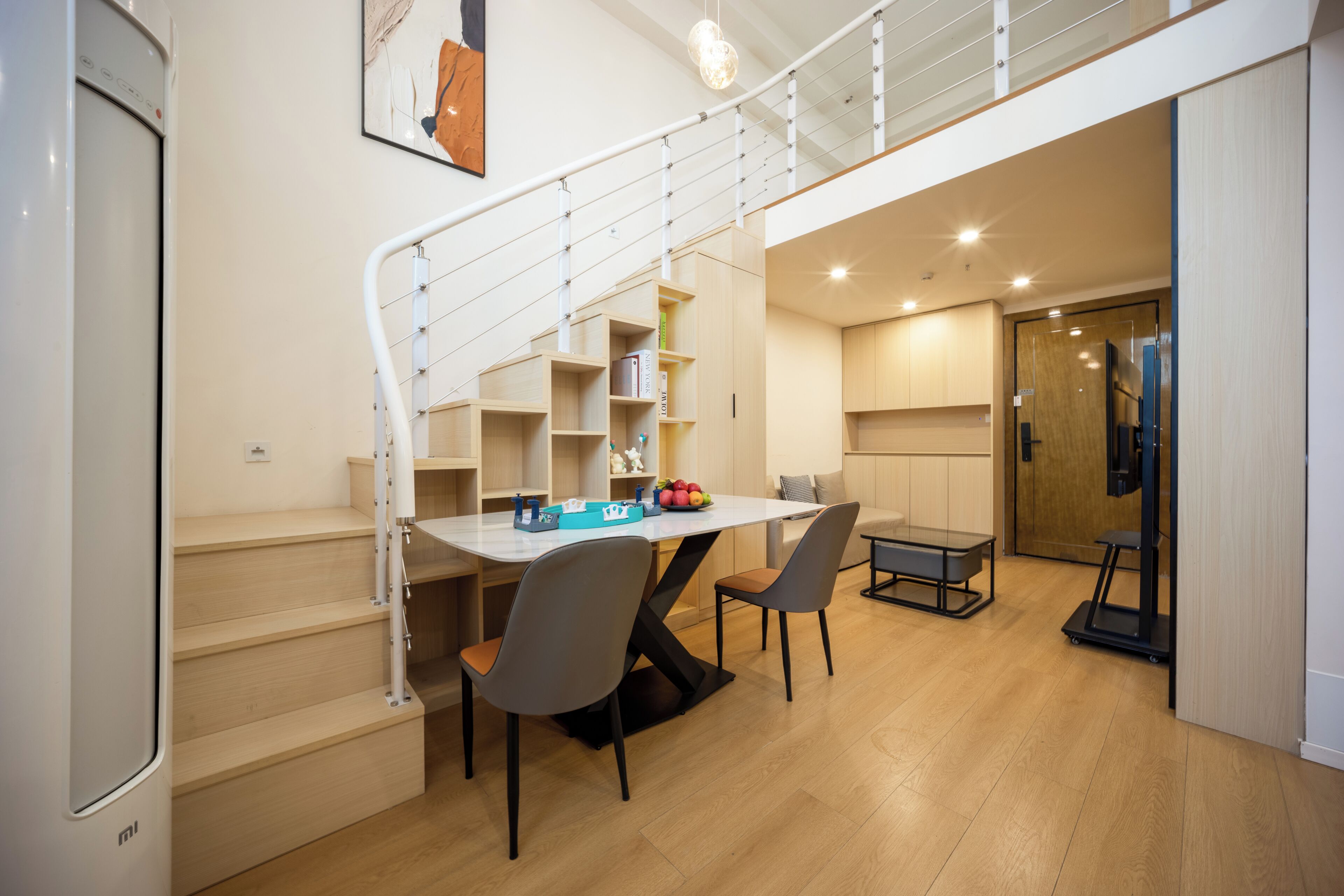 Un interior moderno con escalera, comedor y equipo de ejercicio.