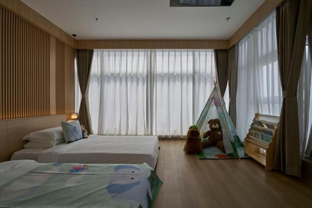 Une chambre d’hôtel avec deux lits, une tente et une bibliothèque.