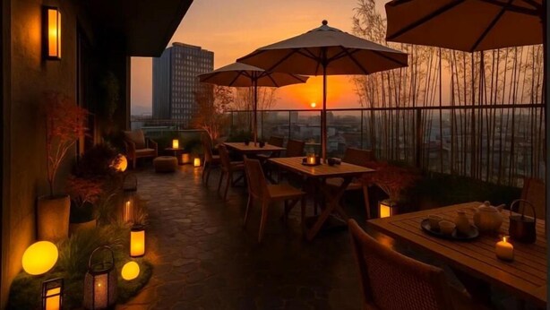 Eine Terrasse im Freien mit Tischen, Stühlen, Sonnenschirmen und Laternen, mit Blick auf eine Stadtlandschaft bei Sonnenuntergang.