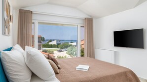 Una camera d'albergo con un letto, una TV e vista mare.