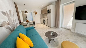 A modern living room with a sofa, a coffee table, and a TV. - Villa Nina - apartment Sea view 30 by Villas Guide (Fažana)