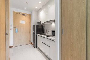 A compact kitchen with a refrigerator, microwave, and sink. - Beachfront Stay Walk to Beach • Gym • Pool C273 (Rawai)