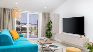 Ein modernes Wohnzimmer mit einer Couch, einem Couchtisch und einem Fernseher.