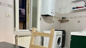Keittiössä on pöytä, pesukone, patteri ja ikkuna.