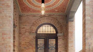 Un edificio con fachada de ladrillo, techo decorativo y puerta doble con ornamentación metálica detallada.