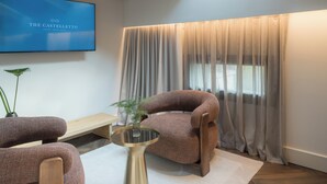 A modern living room with a high ceiling, a skylight, a flat-screen TV, a sofa, a coffee table, and a large window with curtains. - The Castelletto (Montebelluna)