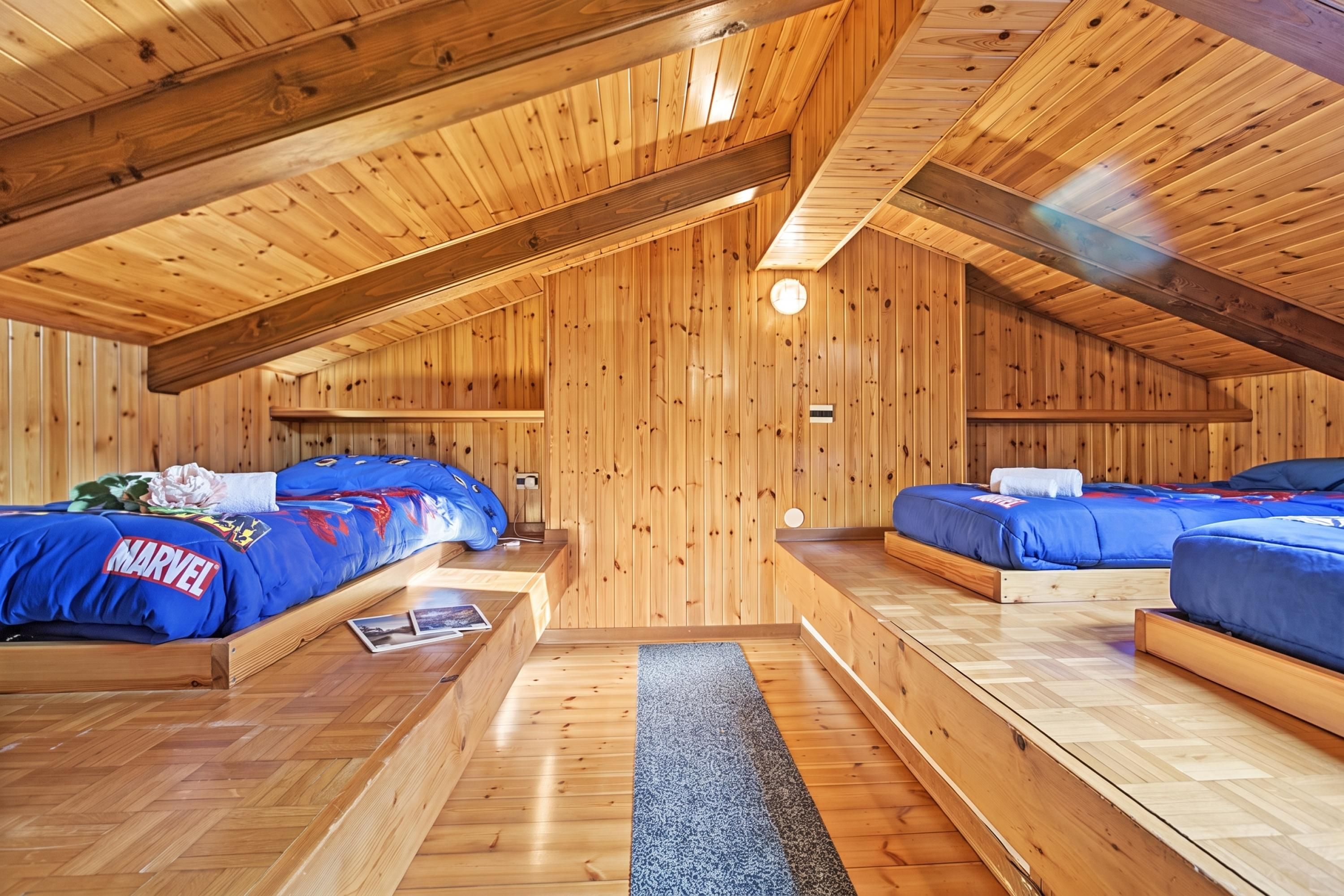 A wooden cabin with two bunk beds, each with a blue blanket and a pillow.