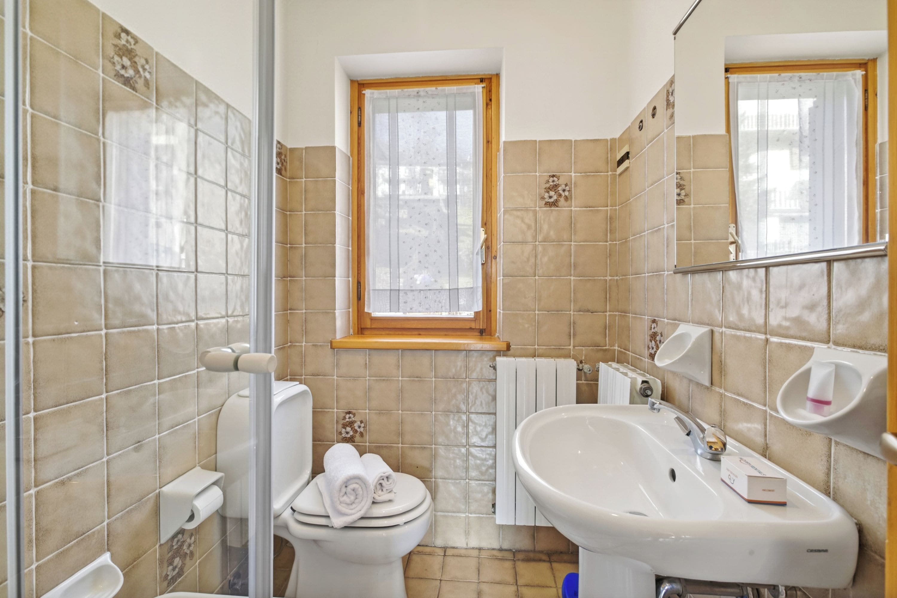 Un baño con inodoro, lavamanos y ventana.