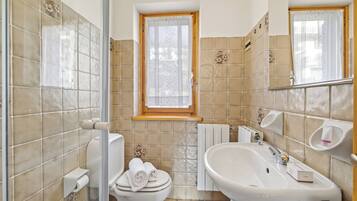 Un baño con inodoro, lavamanos y ventana.