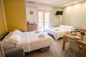 A hotel room with two beds, a dining table, a TV, and a balcony. - La Genzianella - Studio for 4 With Balcony & AC (Andora)