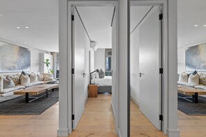 Et moderne interiør med en sofasæt, et træsofabord og en seng med et natbord.