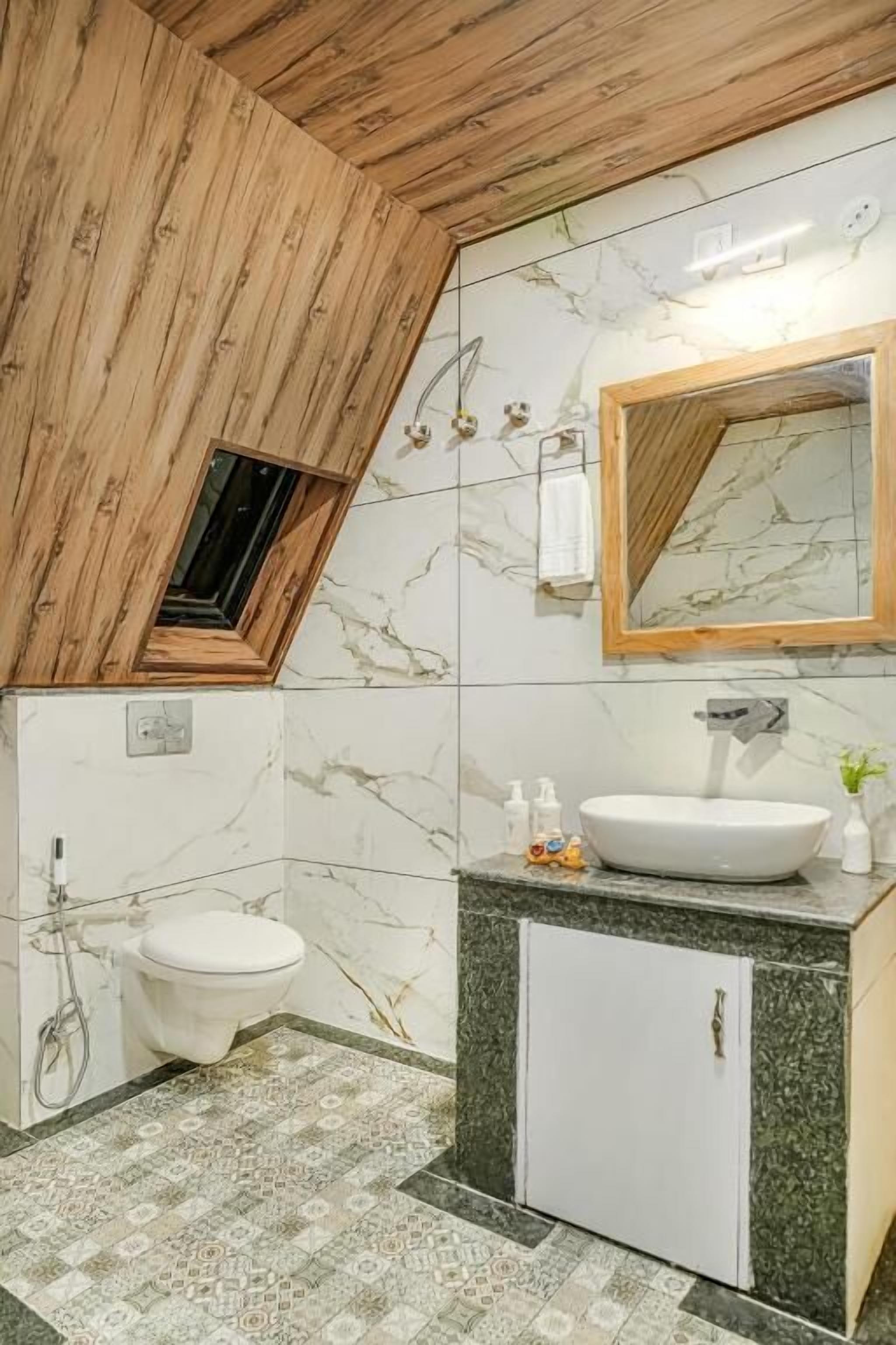Un baño moderno con tragaluz, un lavabo blanco y suelo de baldosas de mármol.